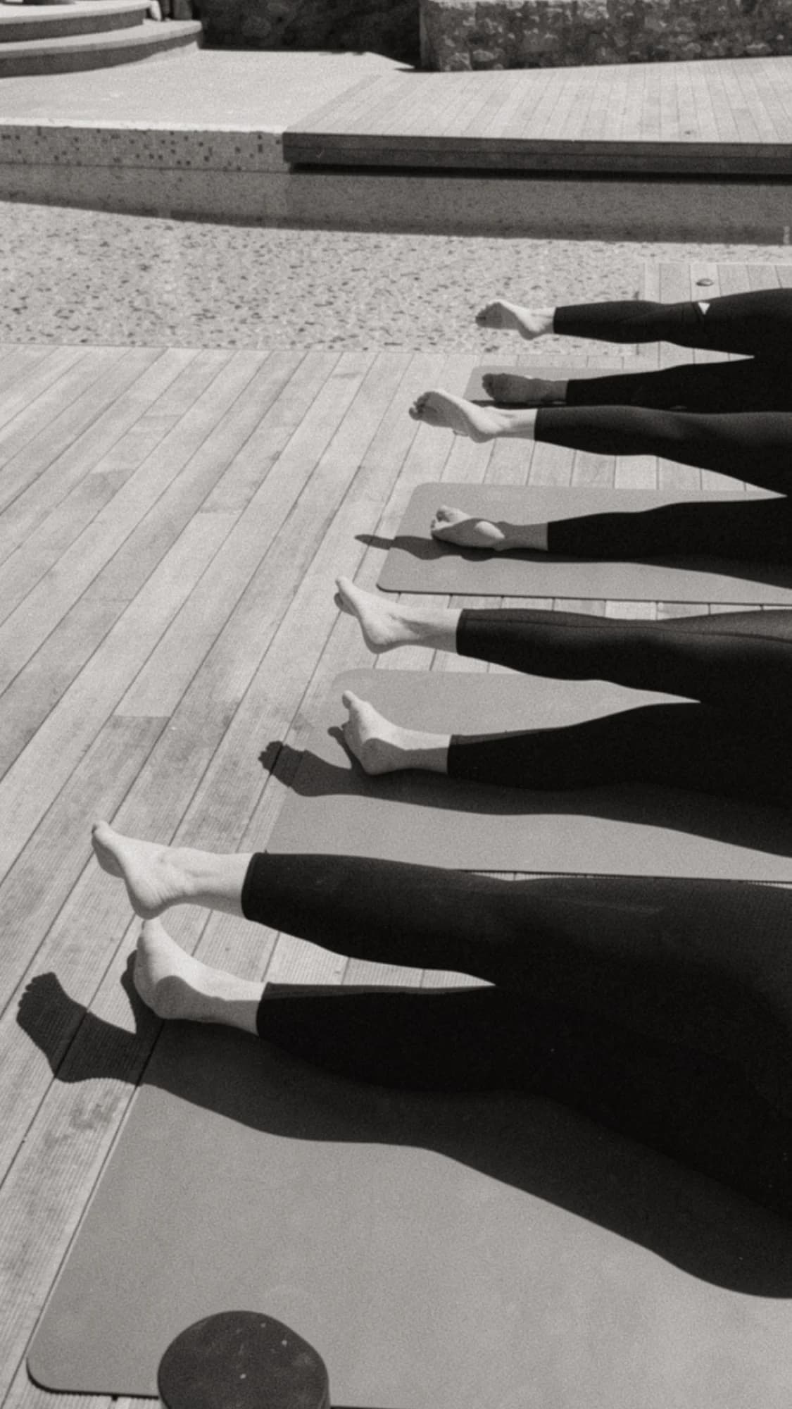 Black-and-white photograph of a row of legs raised in unison on deck