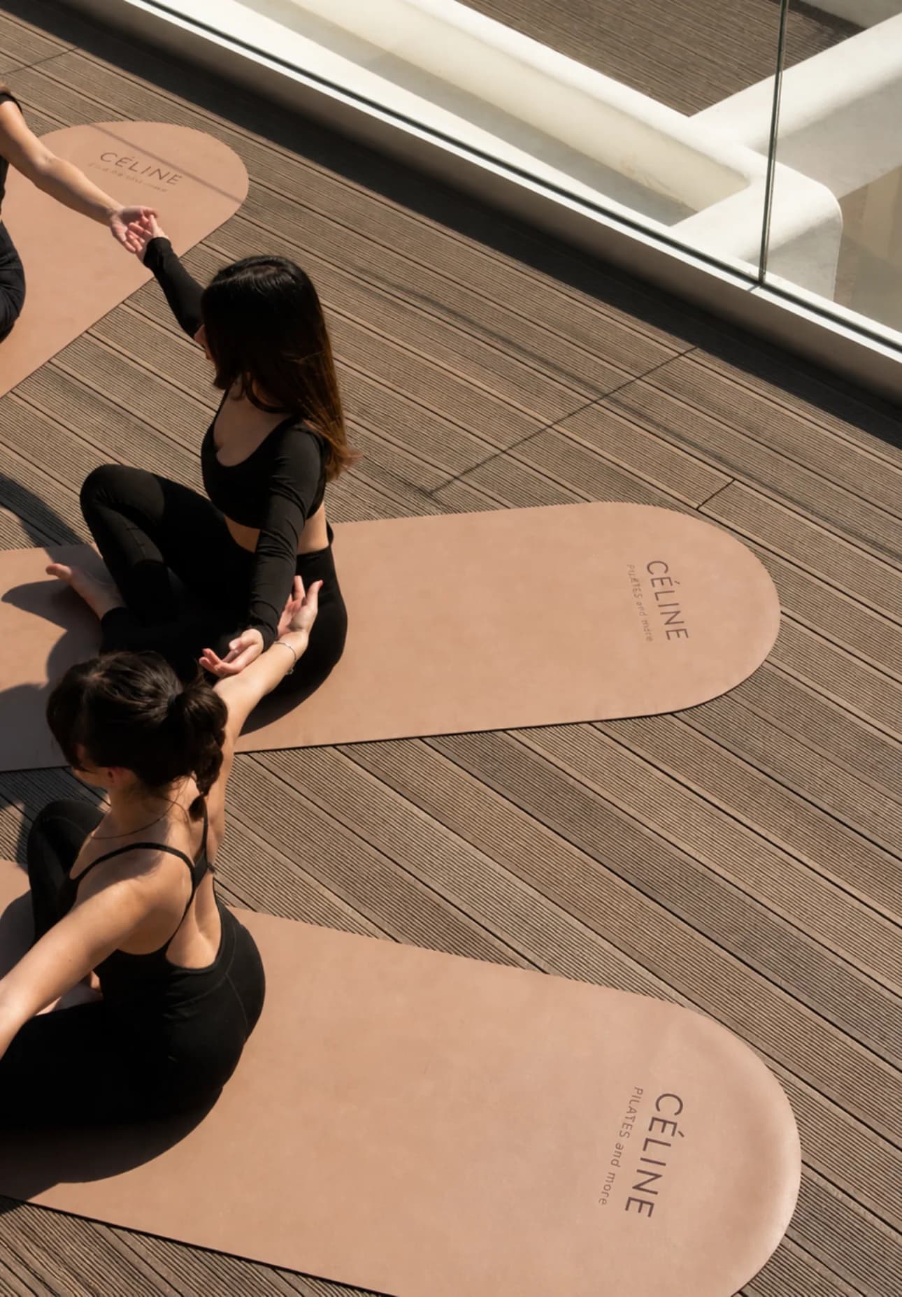 Overhead view of a group mat session on a wooden deck